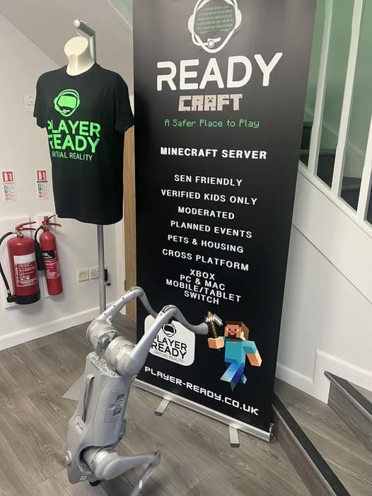 Radar the robot dog next to the READYCraft Minecraft Server banner at Player Ready Exeter